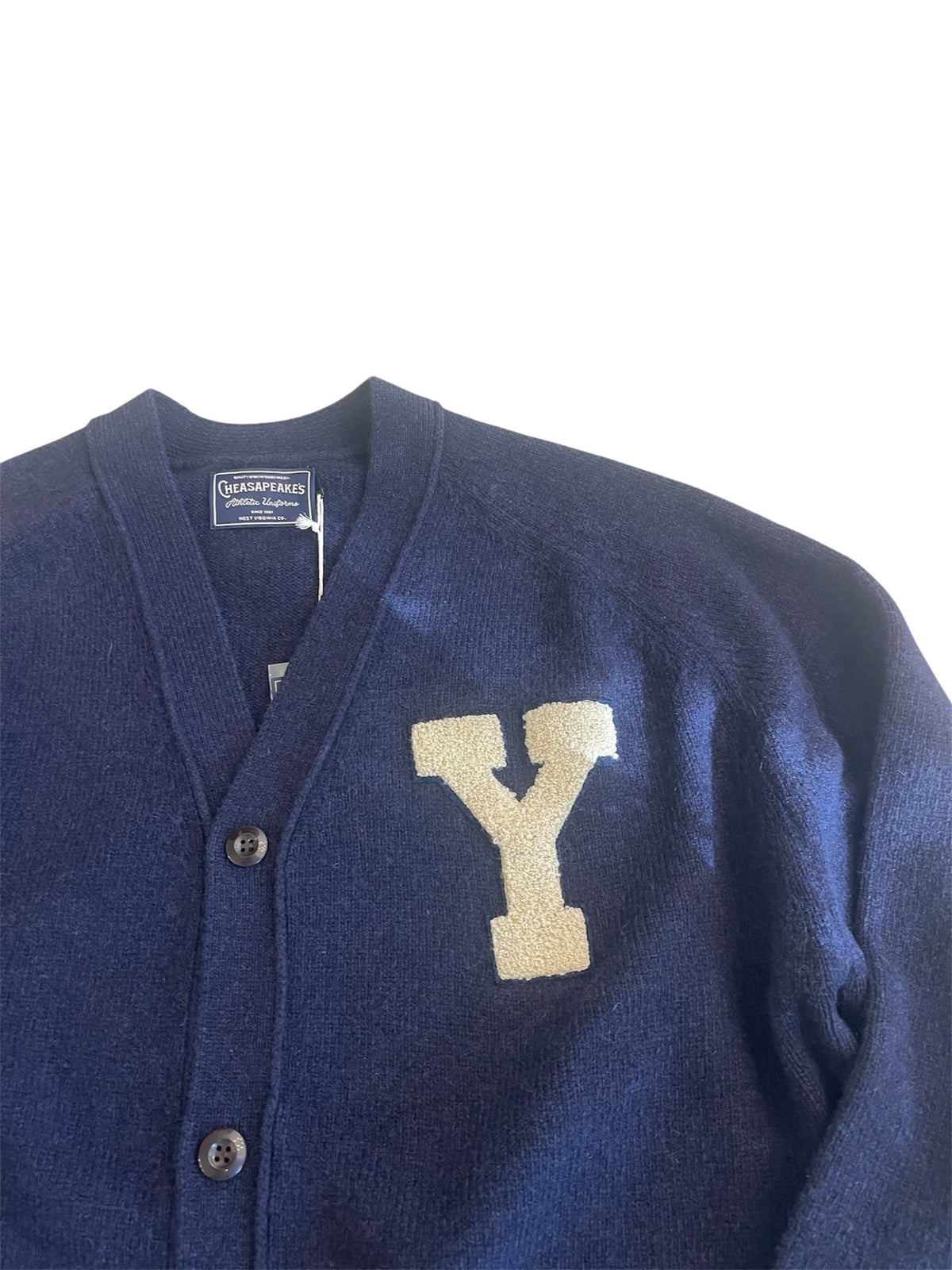 Dettaglio della patch Y écru e della maglia blu del cardigan Chesapeake’s